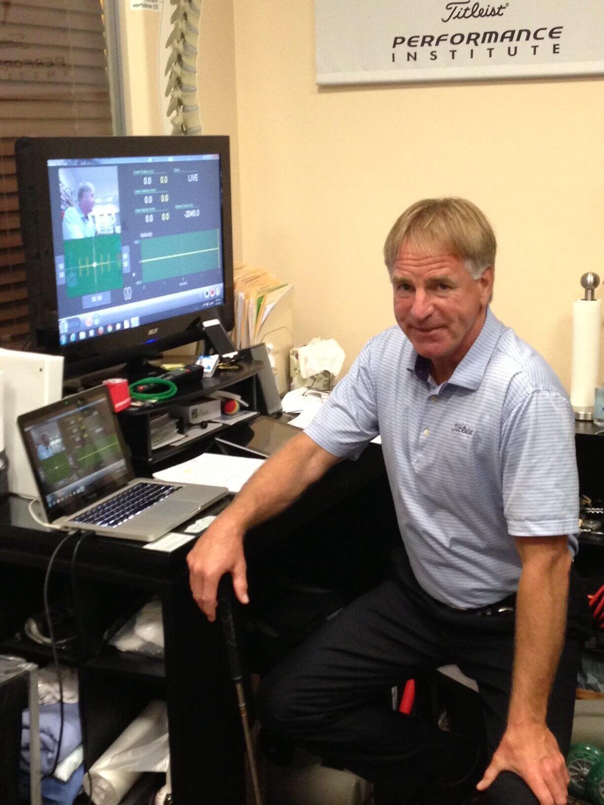 Man in office with golf performance equipment.