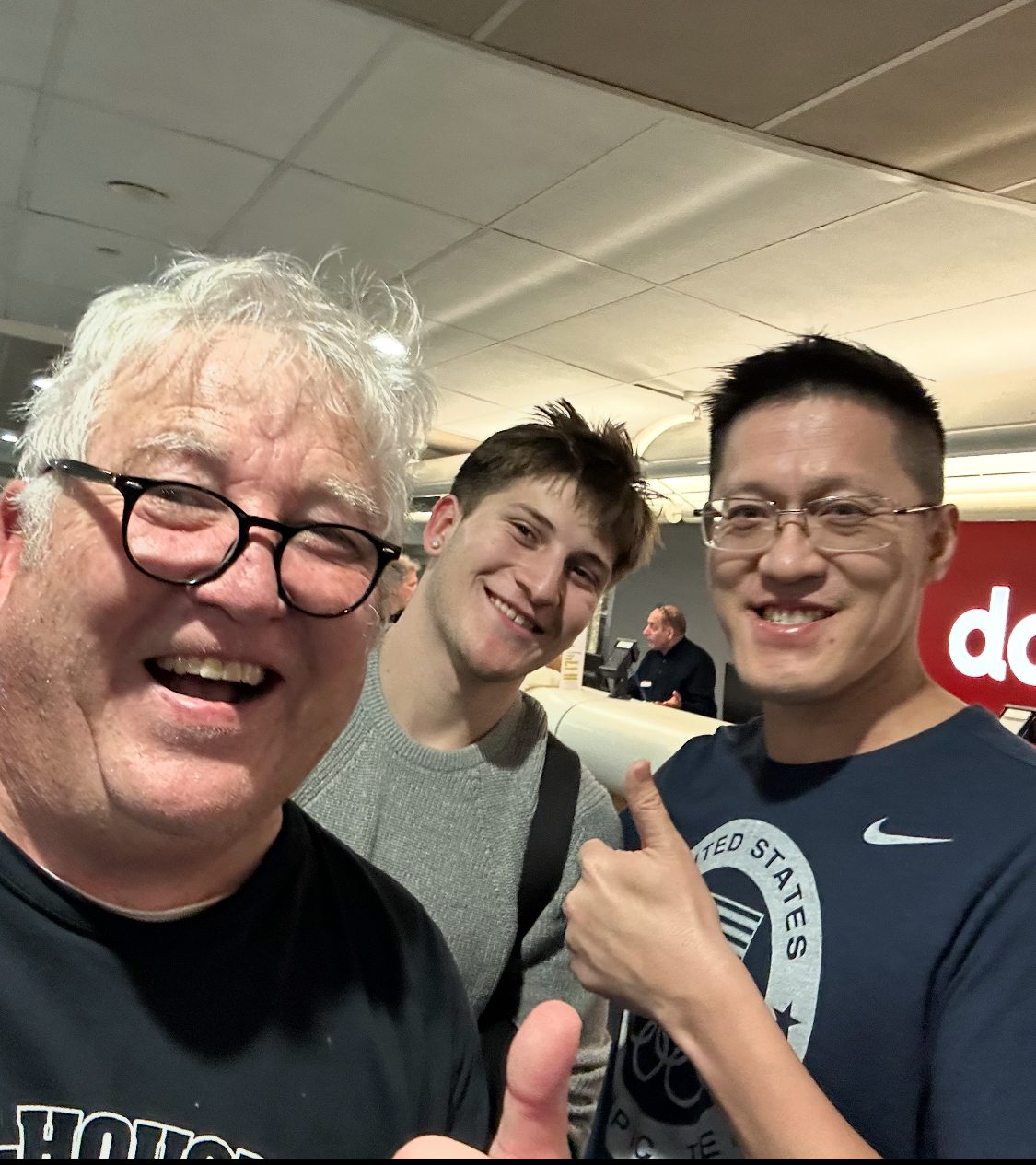 Three people smiling in an indoor setting.